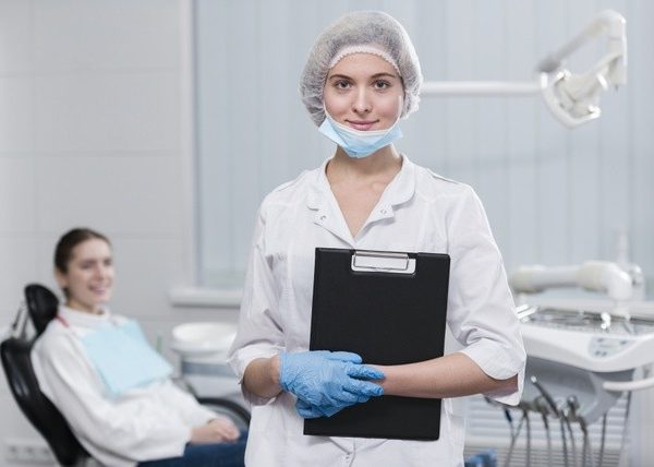 portrait-dentist-holding-clipboard_23-2148396144-600×428